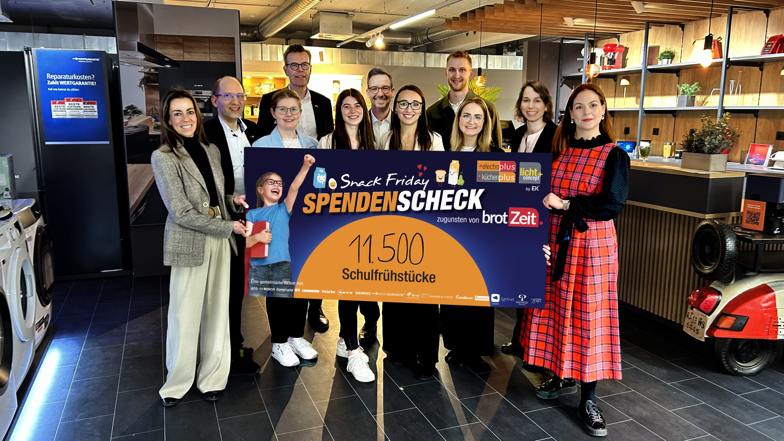 (v. l. n. r.): Margarethe Schlemmer (Vorstandsmitglied, brotZeit e.V.), Christian Claes (Senior Concept Manager küchenplus, EK Retail), Miriam Hofmeister (Junior Online Marketing Manager, EK Retail), Franz Schreckenberg (Team Lead Category Management Electro, EK Retail), Maren Dippel (Junior Online Marketing Manager, EK Retail), Martin Wolf (General Manager EK Home Electrical Appliances, EK Retail), Meike Ullrich (Senior Concept Manager electroplus, EK Retail), Paul Süwer (Team Lead Marketing and E-Commerce, EK Retail), Pia Strieder (E-Commerce Manager, EK Retail), Alice Jank (Category Manager Major Domestic Appliances, EK Retail) und Verena Schmitt (Bereichsleitung Fundraising und Kommunikation, brotZeit e.V.) präsentieren den Spendenscheck über 11.500 Schulfrühstücke.