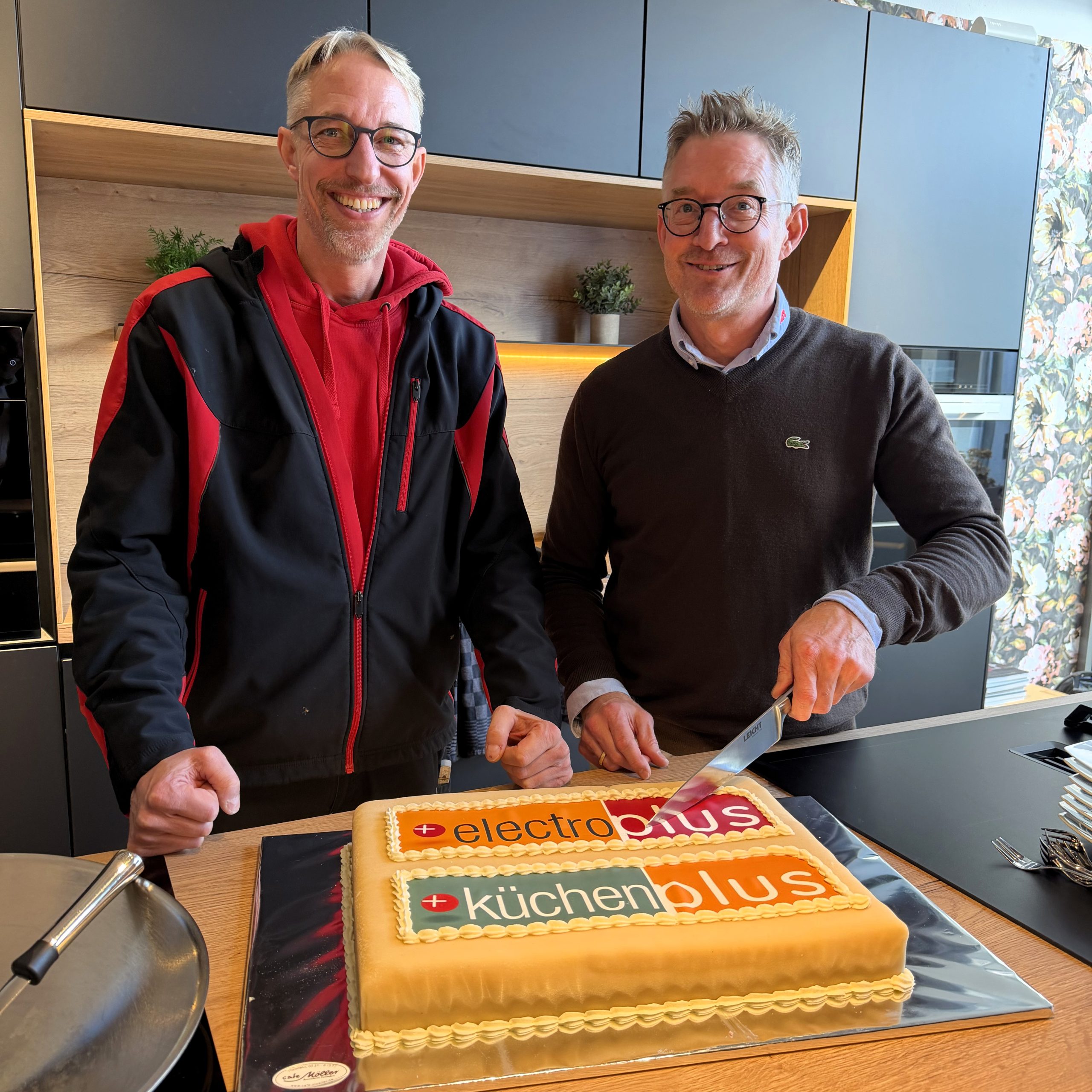 Ulf Scheldt (Geschäftsführer, Elektro Scheldt) und Dirk Scheldt (Geschäftsführer, Elektro Scheldt) schneiden zusammen die electroplus Torte zur Neueröffnung an.