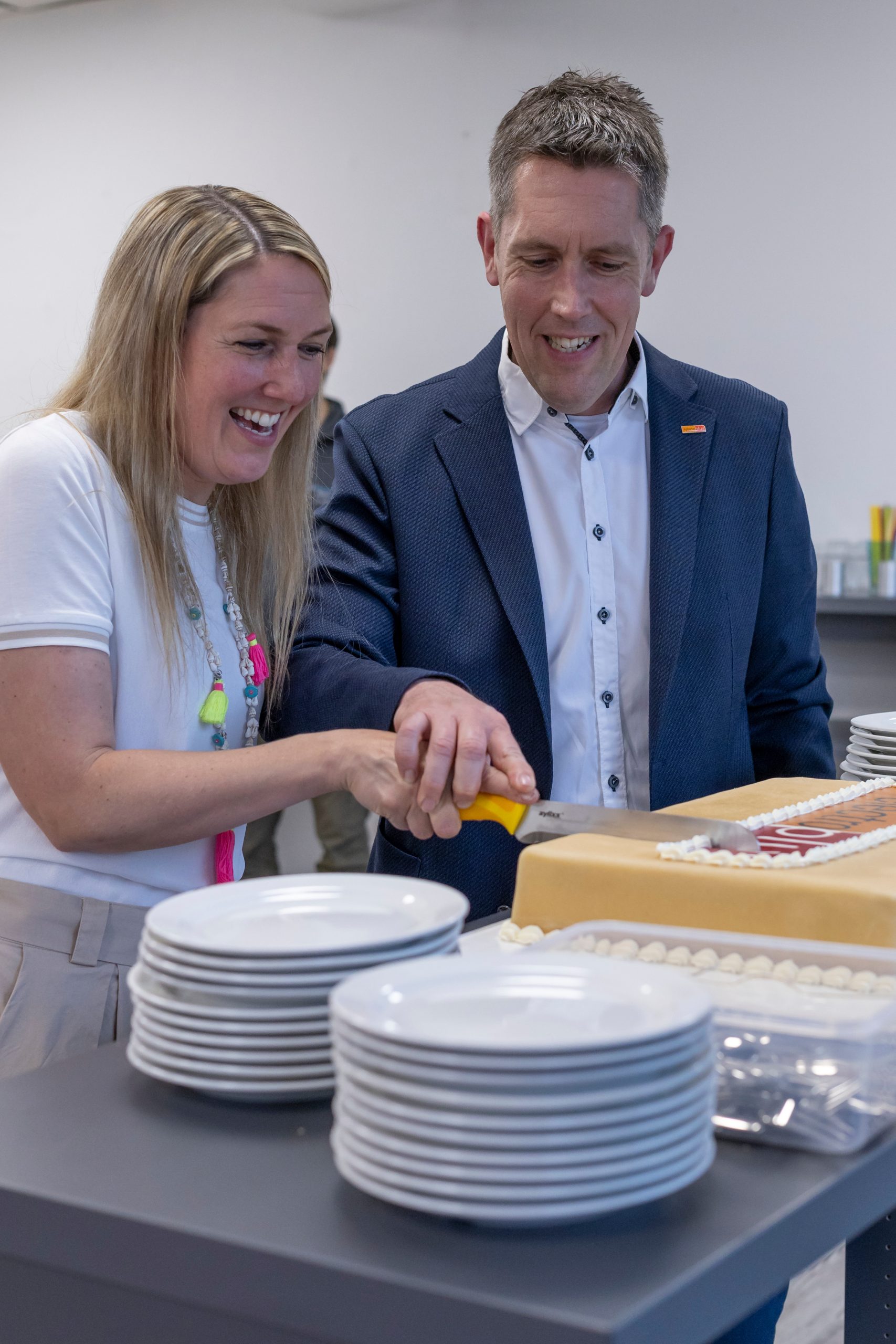 Patrizia Seifert (Inhaberin, Hausgeräte Depot) und Alexander Bahler (Inhaber, Hausgeräte Depot) schneiden zusammen die electroplus Torte zur Neueröffnung an.