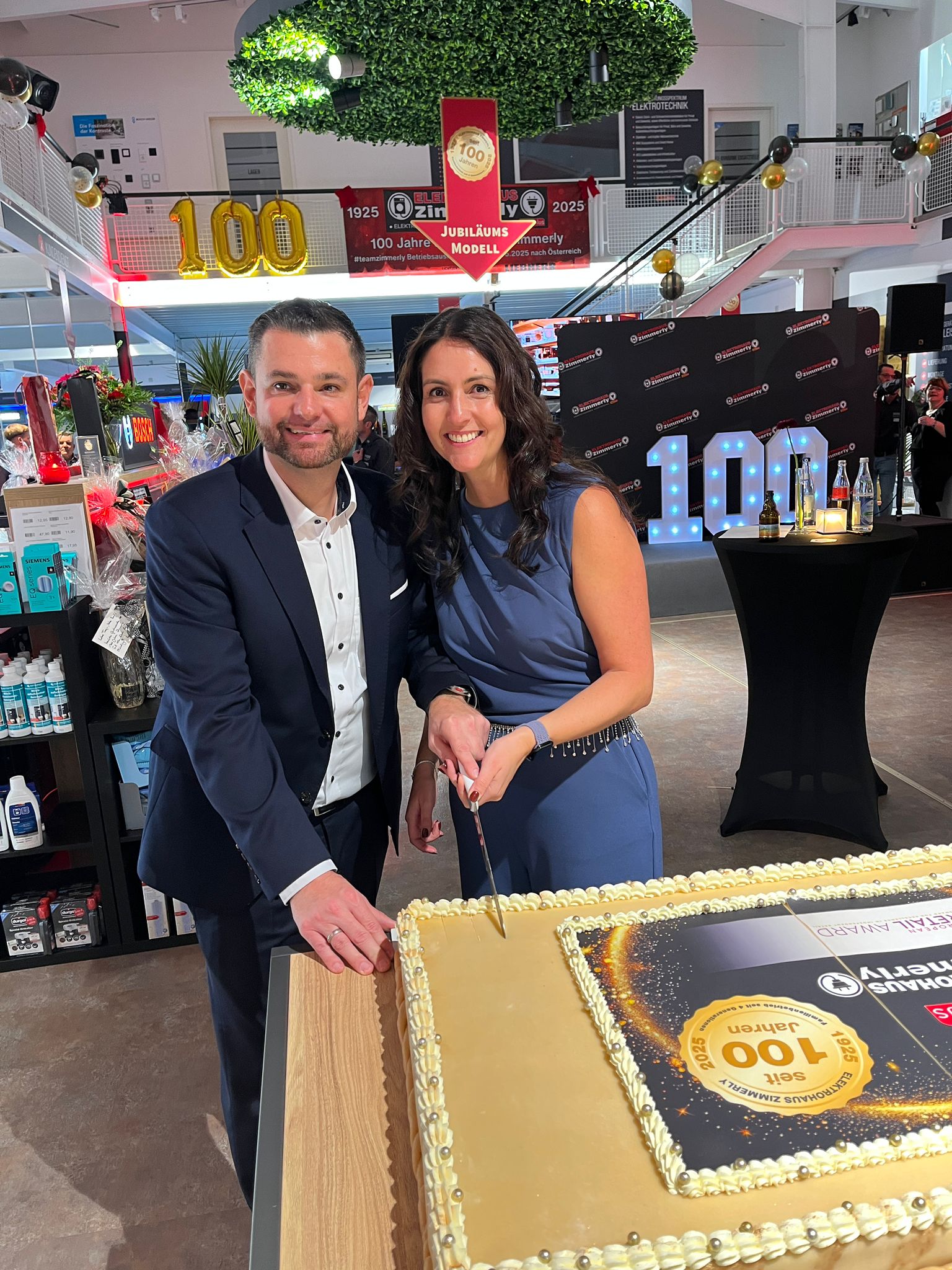Bernd Zimmerly (Geschäftsführer, Zimmerly Elektro GmbH) und Tanja Zimmerly (Prokuristin, Zimmerly Elektro GmbH) schneiden zusammen die electroplus Torte zum Jubiläum an.