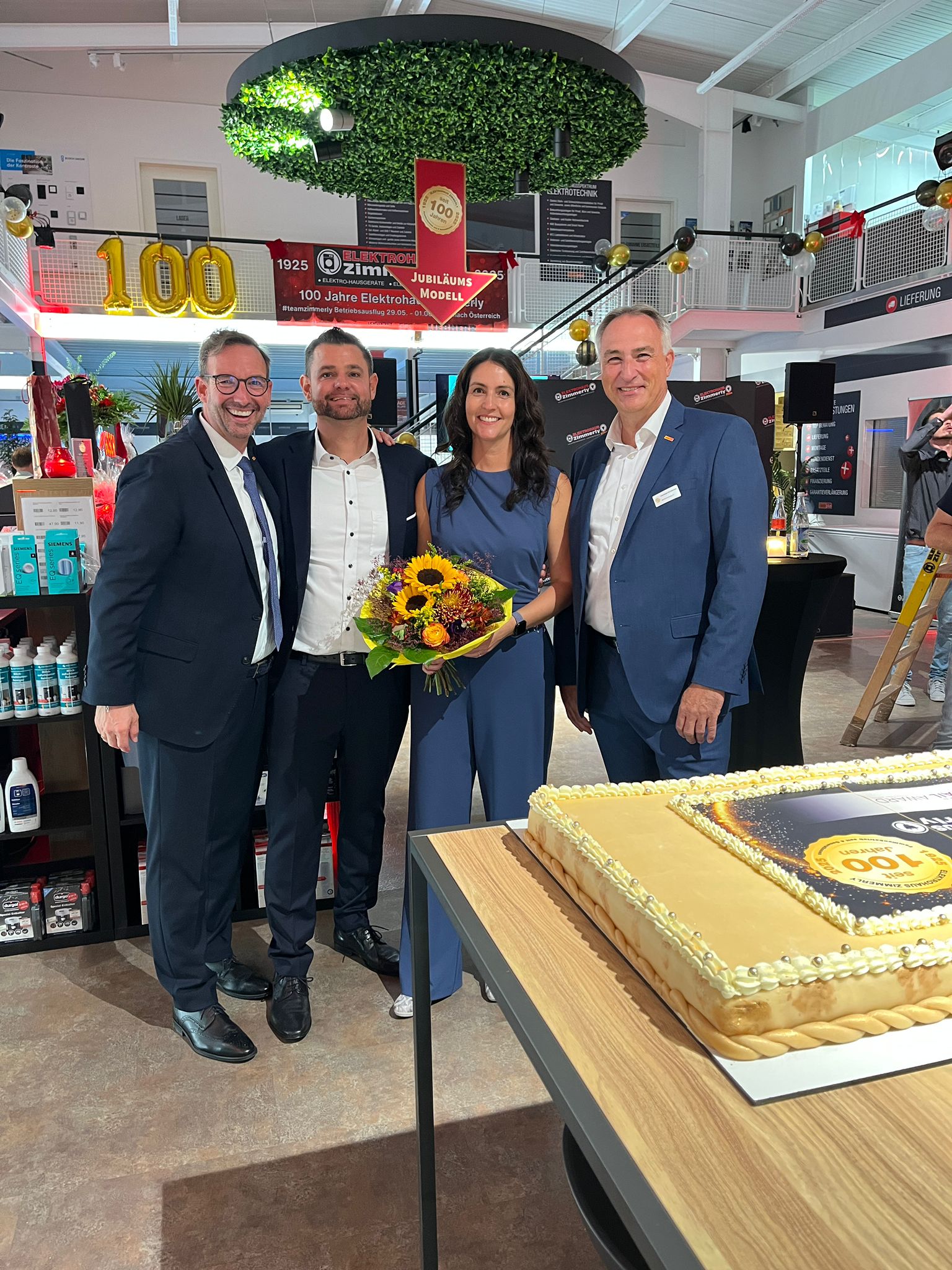 Martin Wolf (General Manager EK Home Electrical Appliances, EK Retail) und Christian Bichlmeier (Regionalleiter electroplus, EK Retail) gratulieren Bernd Zimmerly (Geschäftsführer, Zimmerly Elektro GmbH und Tanja Zimmerly (Prokuristin, Zimmerly Elektro GmbH) zum 100-jährigen Jubiläum von Elektrohaus Zimmerly.