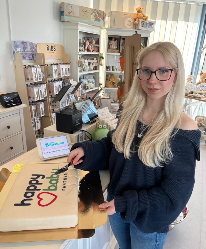 Kimberly Schäfer (Inhaberin, „little sunshine“) beim Anschnitt der happybaby Torte.