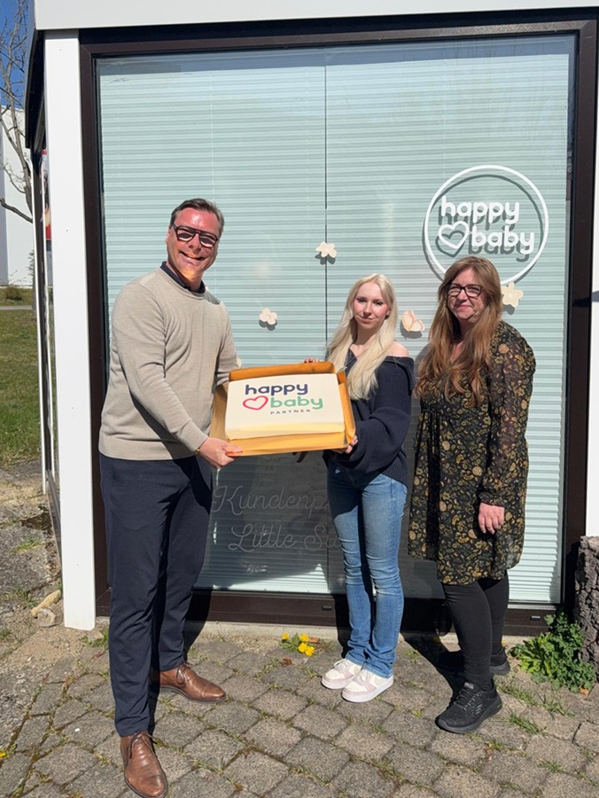 (v. l. n. r.) André Babenhauserheide (General Manager EK Home Baby & Toys, EK Retail), Kimberly Schäfer (Inhaberin, „little sunshine“) und Ihre Mutter Yvonne Schäfer bei der Tortenübergabe in Goslar.